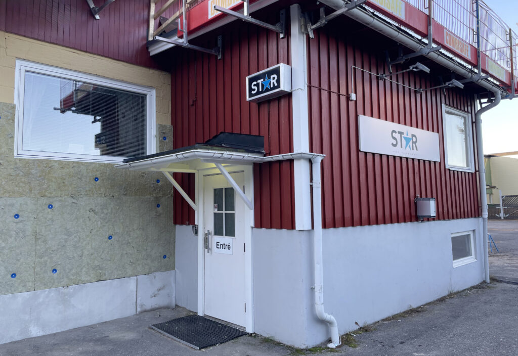 Renovering i solsken: Ställningar täcker fasaden under pågående arbete. Blå himmel och klart solljus speglar byggnadens förändring.