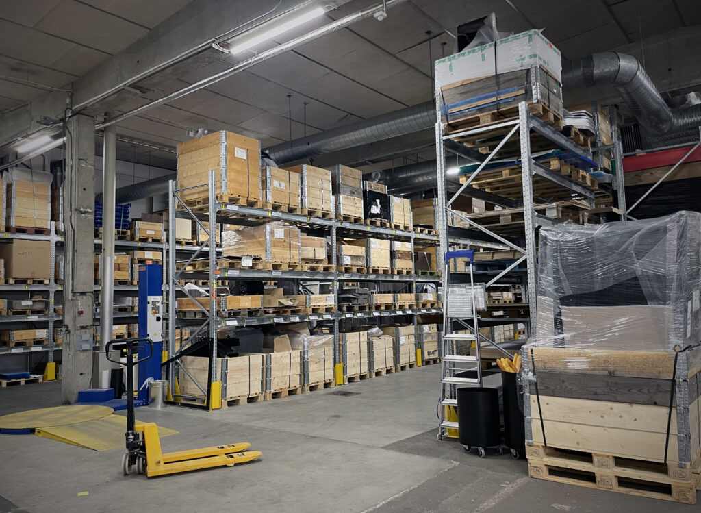 Överblick av ett välordnat lager med raka rader av hyllor och tydliga märkningar som visar var allt hör hemma.