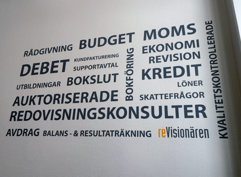 Vägg med typografi där ord som bokslut, budget, revision och moms syns. Längst ner står logotypen reVisionären.